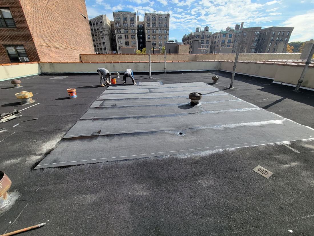 Crew installing modified bitumen roof membrane